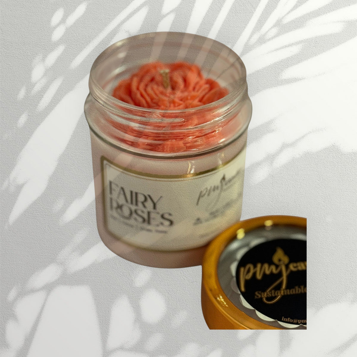PMJ Candles Fairy Roses soy candle in a glass jar with a decorative pink rose-shaped wax top and gold lid