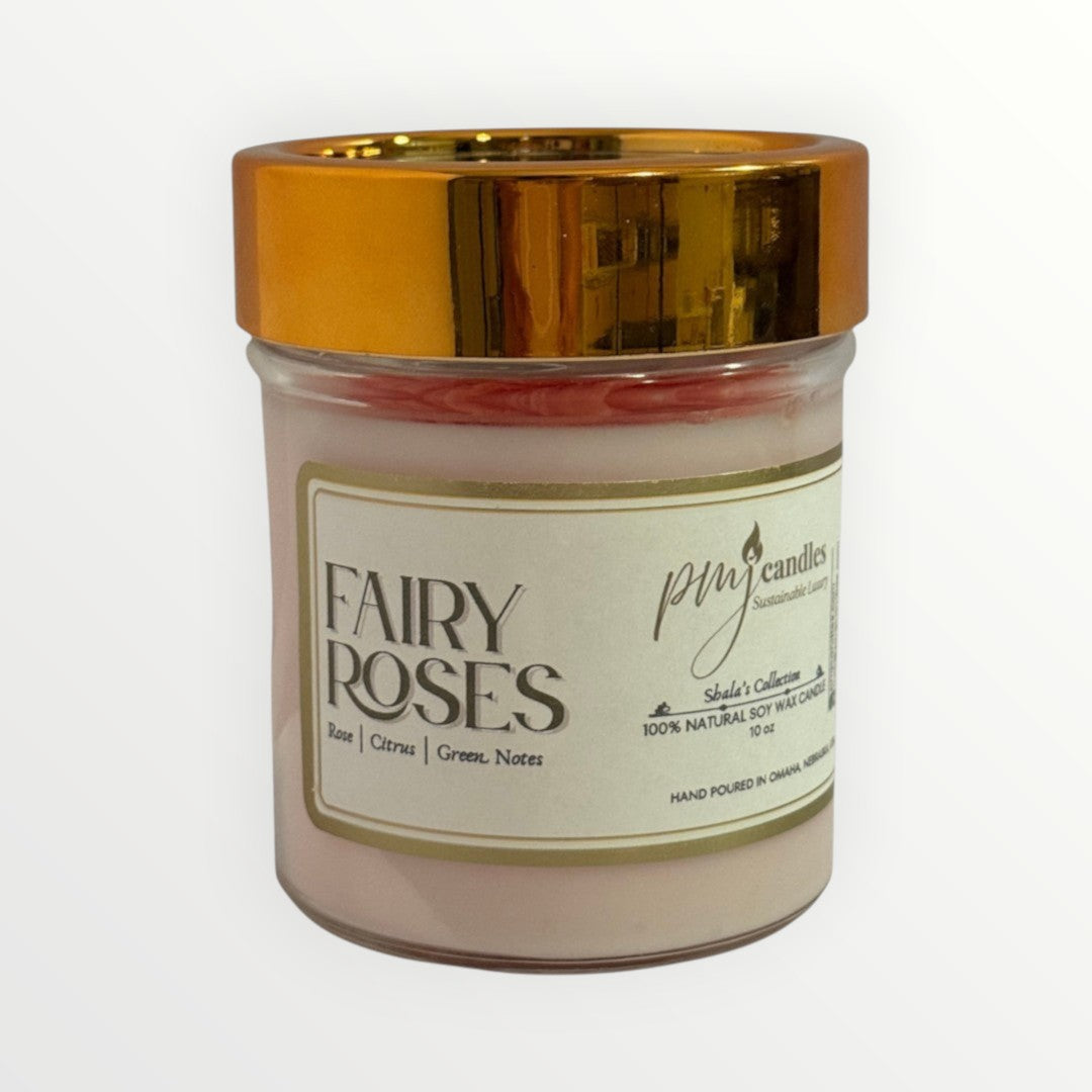 PMJ Candles Fairy Roses soy wax candle in a glass jar with a metallic gold lid, featuring rose and citrus scents.