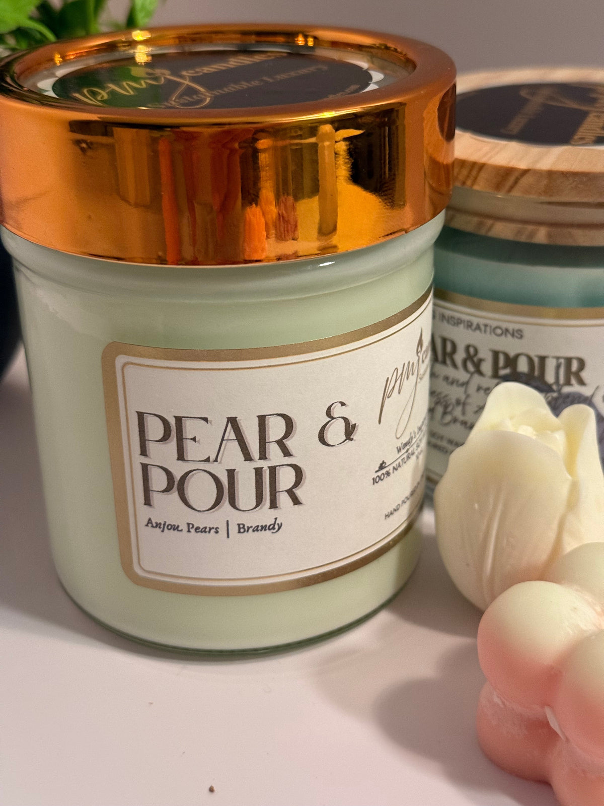 PMJ Candles Pear & Pour soy wax candle in a light green jar with a metallic gold lid and elegant label
