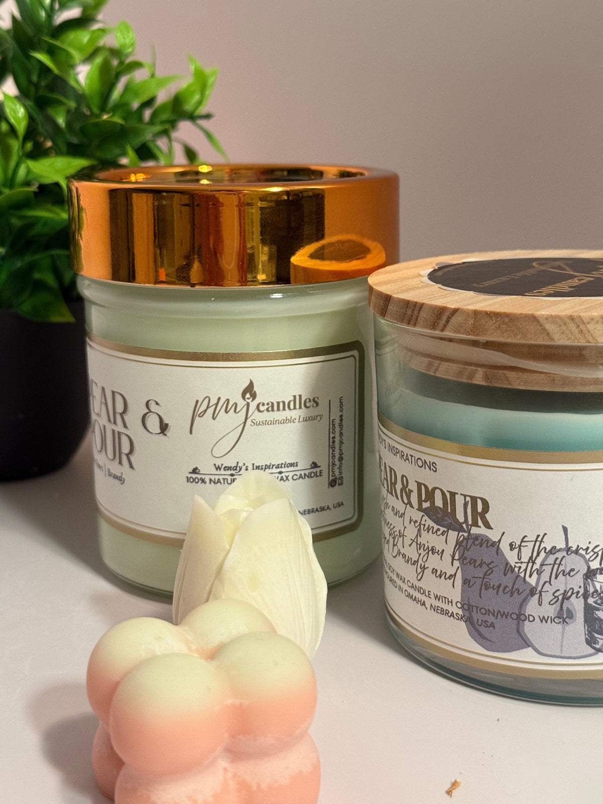 PMJ Candles Pear & Pour soy wax candles in glass jars with gold and wood lids, featuring pear and brandy scent.