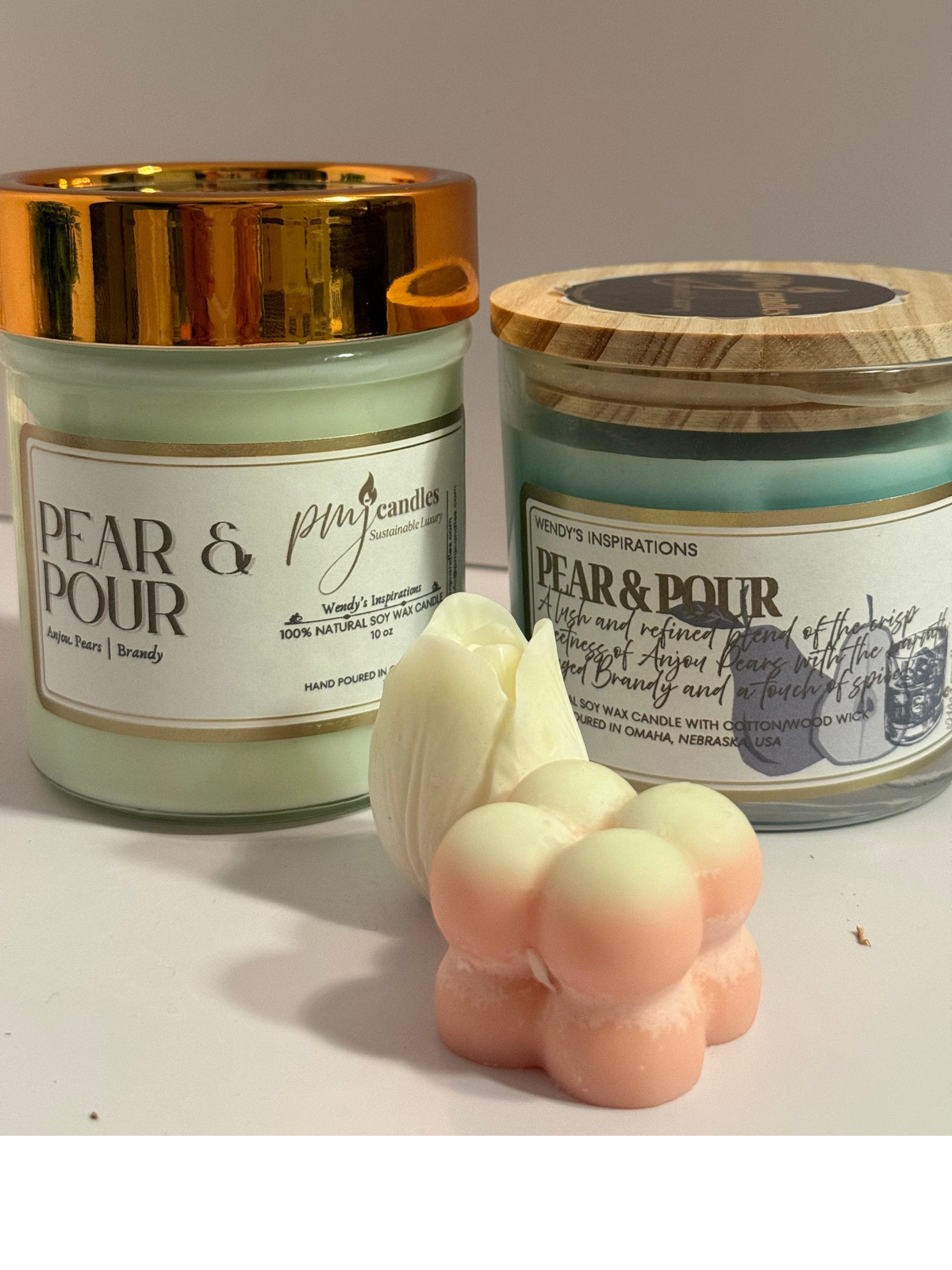 PMJ Candles Pear & Pour soy wax candles in glass jars with gold and wood lids, accompanied by floral wax melts.