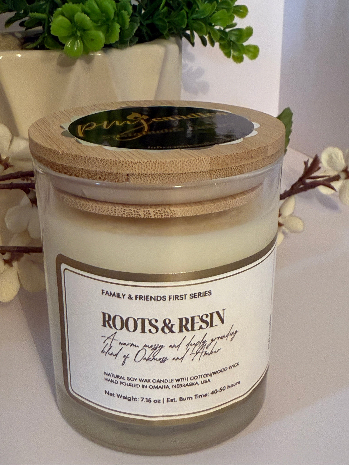 PMJ Candles Roots and Resin soy wax candle in a glass jar with a bamboo lid, featuring earthy cedarwood and amber scent